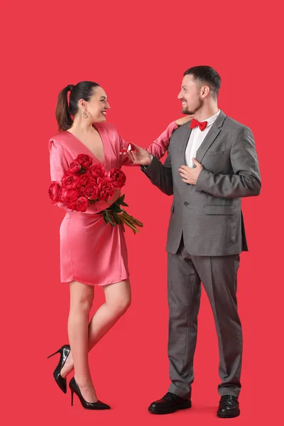 Young Man Proposing His Girlfriend Flowers Red Background — Stock Photo, Image