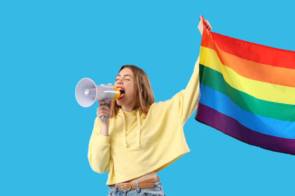 Young woman with LGBT flag shouting into megaphone on blue background