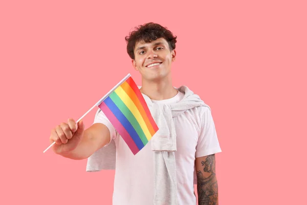 ピンクの背景にLgbtの旗を持つ若い男 — ストック写真