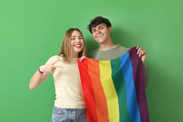 緑の背景にLgbtの旗を持つ若いカップル — ストック写真
