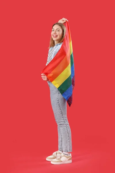 Kırmızı Arka Planda Lgbt Bayrağı Olan Genç Bir Kadın — Stok fotoğraf