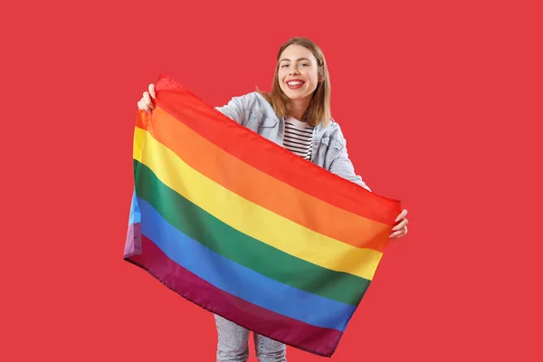 赤い背景にLgbtの旗を持つ若い女性 — ストック写真