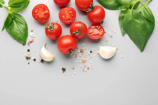Skład Dojrzałych Pomidorów Wiśniowych Liści Bazylii Czosnku Pieprzu Jasnym Tle — Zdjęcie stockowe