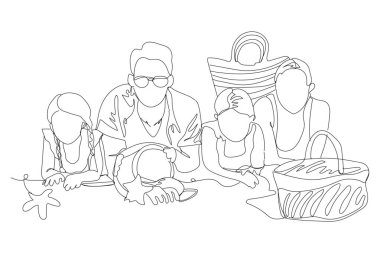 Deniz kıyısındaki kumsalda yatan büyük bir aile.