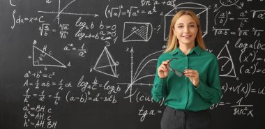 Sınıfta tahtanın yanında olgun matematik öğretmeni.