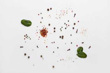 Açık arkaplanda farklı baharatlar ve ıspanak yaprakları
