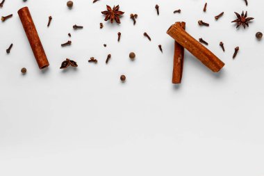 Açık arkaplanda aromatik karanfil, tarçın, tüm baharat ve anason yıldızlı kompozisyon