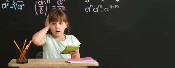 Здивована Маленька Дівчинка Калькулятором Сидить Столом Під Час Уроку Математики — стокове фото