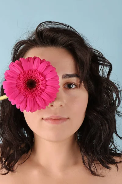Νεαρή Γυναίκα Κλείνει Μάτι Όμορφο Λουλούδι Gerbera Μπλε Φόντο — Φωτογραφία Αρχείου