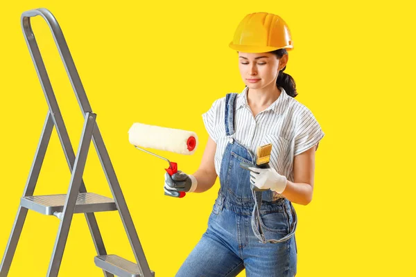 Vrouwelijke Decorateur Met Verfroller Borstel Gele Achtergrond — Stockfoto