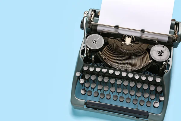 stock image Vintage typewriter with blank paper sheet on blue background