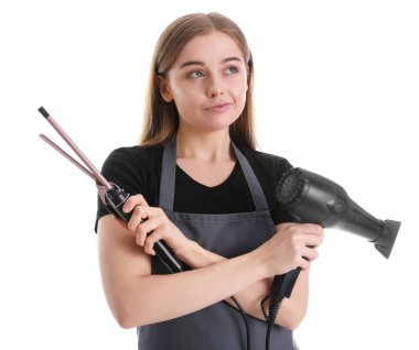 Beyaz arka planda saç maşası ve kurutma makinesi olan düşünceli bir kadın kuaför.