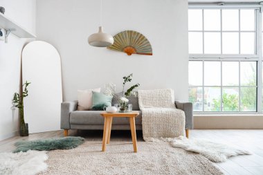 Masa ve kanepede ikebana olan oturma odasının içinde.