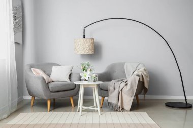 Masada ve koltuklarda ikebana olan oturma odasının içinde.