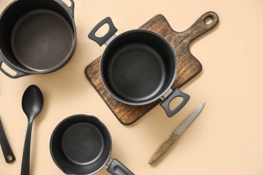Bej arka planda yemek tencereleri ve mutfak aletleri