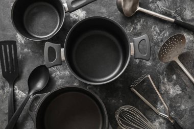 Koyu grunge arka planda yemek tencereleri ve mutfak aletleri