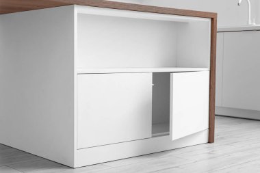 Mutfakta çekmeceleri olan beyaz bir tezgah.