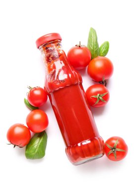 Beyaz arka planda bir şişe ketçap ve domates.