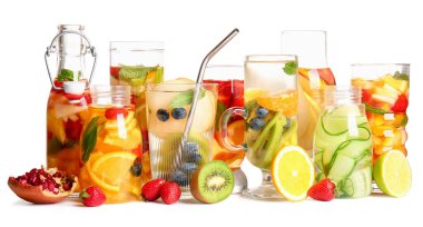 Beyaz arka planda farklı kesilmiş meyvelerle doldurulmuş bardaklar ve şişeler.