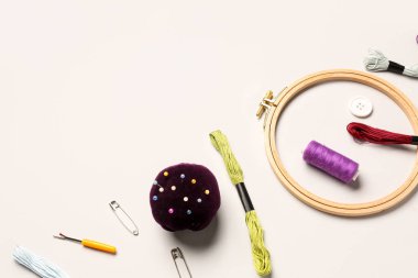 Ahşap işlemeli halka, küf iplikleri ve hafif arka planda dikiş malzemeleri.