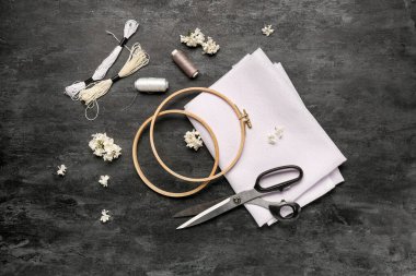 Tuval işlemeli halkalar, küflü iplikler ve grunge siyah arka planda makas.