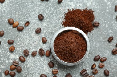 Gri arka planda kahve tozu olan kase