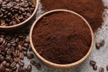 Gri arka planda kahve tozu olan kase