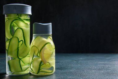 Siyah masada salatalık dilimli spor şişeleri.