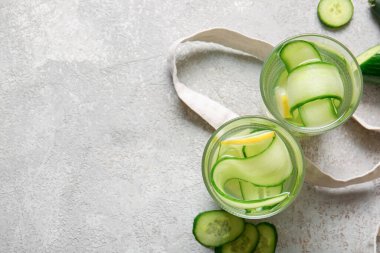 Gri masada salatalık dilimleri ile doldurulmuş su bardakları