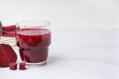 Beyaz arka planda bir bardak taze pancar suyu