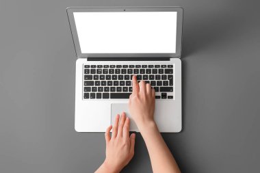Koyu arkaplanda modern dizüstü bilgisayarı olan kadın elleri