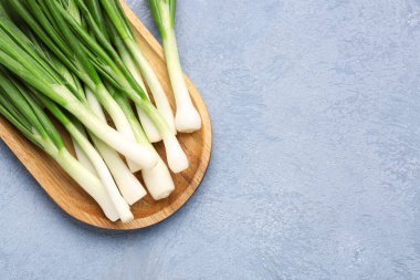 Mavi zemin üzerinde taze yeşil soğan olan tahta