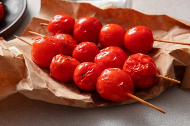 Beyaz arka planda lezzetli ızgara domatesli kağıt ve şişler.