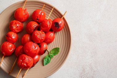 Lezzetli ızgara domatesli şiş tabağı ve beyaz arka planda fesleğen