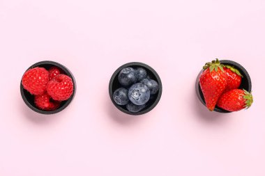 Leylak arka planında farklı taze meyveler olan kaseler.