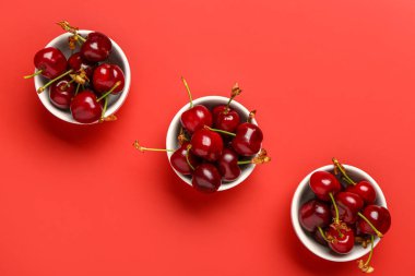 Kırmızı arka planda taze kirazlı kaseler
