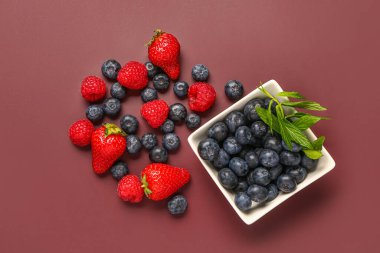 Kırmızı arka planda farklı böğürtlenli kase