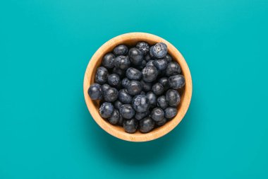 Mavi arka planda taze yaban mersinli kase