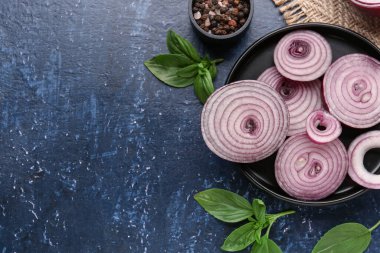 Mavi zemin üzerinde taze soğan dilimleri ve baharatlar olan tabaklar.