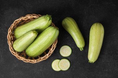 Siyah arka planda taze kabaklı hasır sepet.