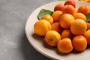 Gri arka planda taze kayısı tabağı