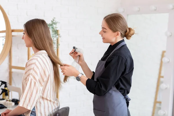 Female Hairdresser Spraying Young Woman Hair Beauty Salon — Stock Photo, Image