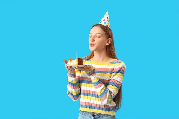 美丽的年轻女子 带着美味的生日蛋糕 在蓝色背景下吹灭蜡烛 — 图库照片