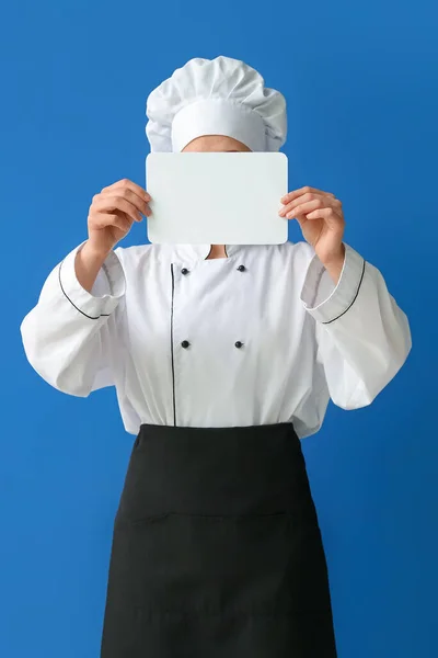 Kadın Aşçı Mavi Arka Planda Boş Bir Kart Tutuyor — Stok fotoğraf