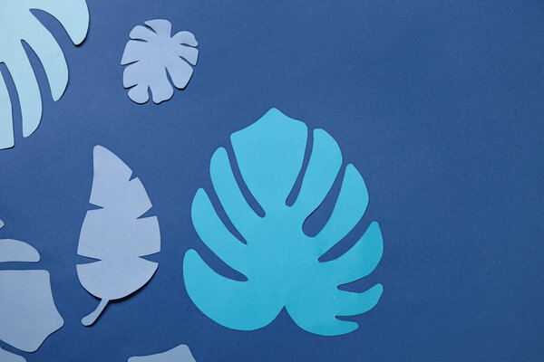 Beautiful origami leaves on blue background