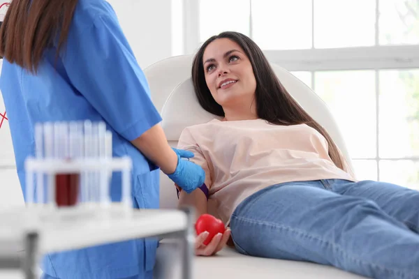 女医生帮助年轻捐献者准备在诊所输血 — 图库照片