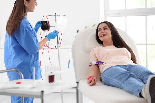 stock image Female nurse preparing young donor for blood transfusion in clinic