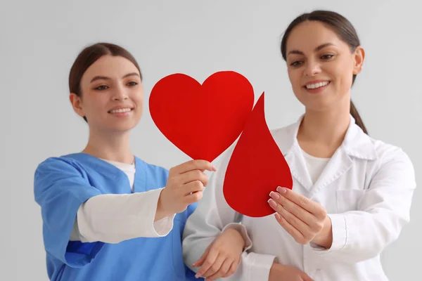 Médico Femenino Con Enfermera Sosteniendo Corazón Papel Gota Sangre Sobre —  Fotos de Stock