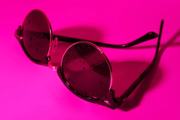 粉色背景水滴的时髦太阳镜 — 图库照片