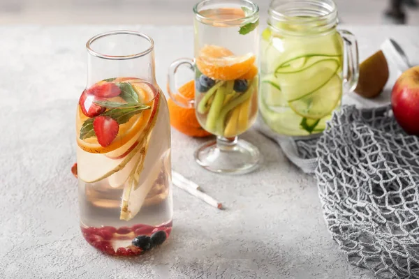 Glas Metselaarspot Flesje Water Met Verschillende Gesneden Vruchten Grijze Tafel — Stockfoto